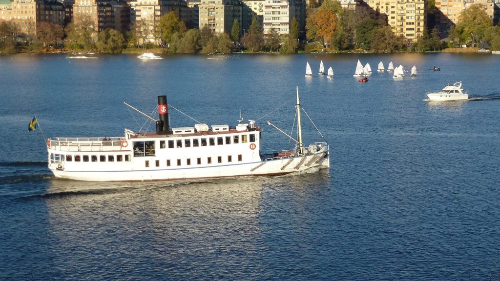 Skärgårdsbåt på Riddarfjärden i Stockholm med höstfärgade träd i bakgrunden
