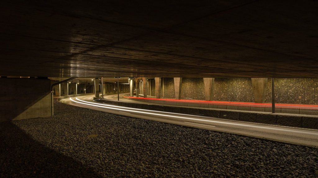 Väg under betongtak vid Norra länken i Stockholm med ljusspår från bilar